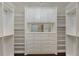 This walk-in closet has white shelving and cabinets for clothes and storage at 1570 Westover Loop, Lake Mary, FL 32746