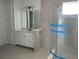 Elegant bathroom with a glass-enclosed shower, sleek vanity, tile flooring, and ample natural light at 16759 Muskgrass Dr, Winter Garden, FL 34787