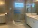 Modern bathroom with a glass-enclosed shower, double vanities, tile floors, and sleek fixtures at 16759 Muskgrass Dr, Winter Garden, FL 34787