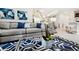 Comfortable living room featuring a gray couch with blue pillows and a stylish blue and white rug at 1781 Sawyer Palm Pl, Kissimmee, FL 34747