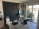 Bright dining room with glass table, black chairs, modern light fixture, black accent wall, and sliding glass doors at 1935 Conway Rd # T6, Orlando, FL 32812