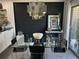 Contemporary dining space with glass table, sleek chairs, modern light fixture, and black accent wall near the kitchen at 1935 Conway Rd # T6, Orlando, FL 32812