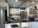 Modern kitchen boasts sleek stainless steel appliances, white cabinetry, breakfast bar, and unique brick backsplash at 1935 Conway Rd # T6, Orlando, FL 32812