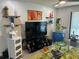 Cozy living room featuring a large TV, white walls, minimalist decor, and floating shelves at 1935 Conway Rd # T6, Orlando, FL 32812