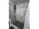 Modern shower features stylish marble-patterned walls, a black honeycomb tile floor, and a built-in niche for toiletries at 1935 Conway Rd # T6, Orlando, FL 32812
