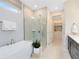 Bright bathroom featuring a soaking tub, glass enclosed shower, and walk-in closet at 1938 Spring Shower Cir, Kissimmee, FL 34744