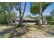 View of backyard and covered patio surrounded by mature trees and landscaping at 2082 Nexus Ct, Apopka, FL 32712