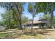 Wide view of backyard and covered patio surrounded by trees and landscaping at 2082 Nexus Ct, Apopka, FL 32712