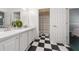 Bright bathroom with black-and-white checkered floor and a double sink vanity with white cabinets at 2082 Nexus Ct, Apopka, FL 32712