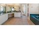 Elegant bathroom featuring marble countertops, white cabinetry, tiled floors, and spa bathtub at 2082 Nexus Ct, Apopka, FL 32712
