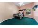 Cozy bedroom with peach-colored walls and green carpet, featuring a bed and built-in shelving at 2082 Nexus Ct, Apopka, FL 32712
