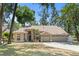 Inviting single-story home featuring a spacious three-car garage, lush green lawn, and meticulously maintained landscaping at 2082 Nexus Ct, Apopka, FL 32712
