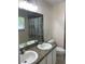 Bathroom with a large mirror, double sinks, and a shower-tub combo provides a functional and stylish space at 2164 Black Mangrove Dr, Orlando, FL 32828