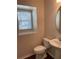 Cozy half-bathroom featuring a pedestal sink, toilet, and window at 2164 Black Mangrove Dr, Orlando, FL 32828