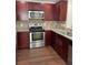 Well-equipped kitchen featuring stainless steel appliances, wood cabinets, and granite countertops at 2164 Black Mangrove Dr, Orlando, FL 32828