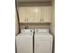 Laundry room with a washer and dryer, complemented by storage cabinets above at 2164 Black Mangrove Dr, Orlando, FL 32828