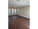 Open living room featuring hardwood floors, neutral walls, three windows and a ceiling fan at 2164 Black Mangrove Dr, Orlando, FL 32828