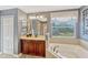 A primary bathroom showcasing a soaking tub, wooden vanity, and a separate glass shower at 2401 Home Again Rd, Apopka, FL 32712