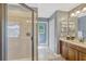 The primary bathroom showcases a glass enclosed shower, wooden vanity, and separate toilet area at 2401 Home Again Rd, Apopka, FL 32712