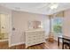 Pretty bedroom featuring wood floors, large white dresser, ceiling fan, and window views to the outside at 2401 Home Again Rd, Apopka, FL 32712