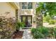 Home entrance featuring glass doors and stone facade accented by healthy greenery at 2401 Home Again Rd, Apopka, FL 32712