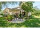 Charming home exterior featuring a stone accent wall and inviting front patio seating area surrounded by lush landscaping at 2401 Home Again Rd, Apopka, FL 32712