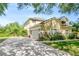 Exterior shot shows long driveway leading to the home's two-car garage, highlighted by stonework and manicured lawn at 2401 Home Again Rd, Apopka, FL 32712