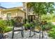 Close up of front exterior showing a charming seating area surrounded by lush vegetation and a stone facade at 2401 Home Again Rd, Apopka, FL 32712