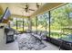 Screened lanai with comfortable seating, ceiling fan, and a view of the lush backyard at 2401 Home Again Rd, Apopka, FL 32712