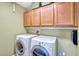 Efficient laundry room with washer, dryer, and ample wooden cabinet storage at 2401 Home Again Rd, Apopka, FL 32712