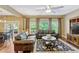 Comfortable living room with hardwood floors, leather sofas, large windows, and a ceiling fan for relaxed living at 2401 Home Again Rd, Apopka, FL 32712