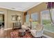 Living room features hardwood floors, comfortable seating and exterior views through large windows at 2401 Home Again Rd, Apopka, FL 32712
