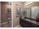 Stylish bathroom with dark wood vanity, decorative mirror, and tiled flooring at 2458 Dream Home Ct, St Cloud, FL 34772