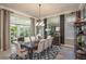 Formal dining room features a modern chandelier, large mirror, and access to an outdoor patio at 2458 Dream Home Ct, St Cloud, FL 34772