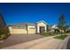 Inviting home exterior features a two-car garage, paver driveway, and beautifully landscaped yard under a clear blue sky at 2458 Dream Home Ct, St Cloud, FL 34772