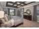 Luxurious main bedroom with coffered ceilings, a chandelier, and large windows providing natural light at 2458 Dream Home Ct, St Cloud, FL 34772