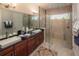 Elegant bathroom with a dual vanity, stone countertops, a glass enclosed shower, and modern fixtures at 2460 Dream Home Ct, St Cloud, FL 34772