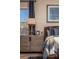Comfortable bedroom with stylish nautical decor, wood nightstand, and natural lighting through a window at 2460 Dream Home Ct, St Cloud, FL 34772