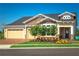 Desirable home featuring a brick driveway, three-car garage, and a covered front porch at 2460 Dream Home Ct, St Cloud, FL 34772