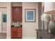 Hallway with a small wet bar and a sailboat painting on the wall; white orchids on a table at 2460 Dream Home Ct, St Cloud, FL 34772