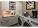 Functional laundry room with built-in cabinets, granite countertops, and modern washer and dryer units at 2460 Dream Home Ct, St Cloud, FL 34772