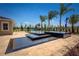 A modern pool area with a tiered water feature, set against a clear blue sky and lush landscaping, promising a serene retreat at 2460 Dream Home Ct, St Cloud, FL 34772