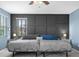 Serene bedroom featuring two beds, a gray accent wall, and soft lighting at 2628 Cedar Shake Ct, Oviedo, FL 32765