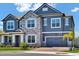 Charming two-story home with stone accents, blue siding, lush landscaping, and a convenient two-car garage at 2628 Cedar Shake Ct, Oviedo, FL 32765
