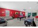 Spacious game room with a red accent wall, pool table, arcade games, and comfortable seating area at 2628 Cedar Shake Ct, Oviedo, FL 32765