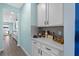 Hall access with bar/kitchenette area, light countertops, white cabinets, and gray subway tile at 2628 Cedar Shake Ct, Oviedo, FL 32765
