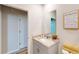 Clean bathroom with a neutral vanity, decorative mirror, and a door leading to a separate area at 264 Towns Cir, Haines City, FL 33844