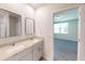 Stylish bathroom boasts double sinks, granite countertops, framed mirrors, and access to the bedroom, creating a luxurious ambiance at 264 Towns Cir, Haines City, FL 33844