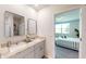 Elegant bathroom featuring a double sink, large mirror, and a doorway view to the bedroom at 264 Towns Cir, Haines City, FL 33844