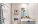 Bright and clean bathroom featuring a tiled shower, modern vanity, and beach themed accents at 264 Towns Cir, Haines City, FL 33844